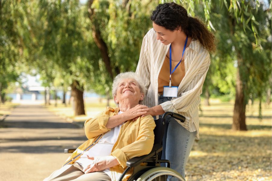 Support worker assisting an elderly client outdoors in Perth